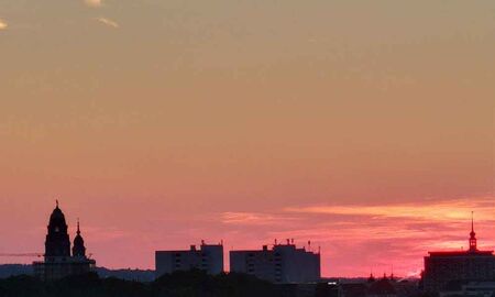 Rosa-oranger Sonnenuntergang über der Dresdner Skyline mit Frauenkirche, passend zum Gedicht "Mosaik des Himmels" von Frank Wollmann