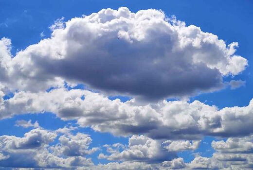 Weiße Schäfchenwolken (Wolkenschafe) ziehen vor strahlend blauem Himmel