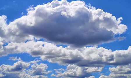 Weiße Schäfchenwolken (Wolkenschafe) ziehen vor strahlend blauem Himmel